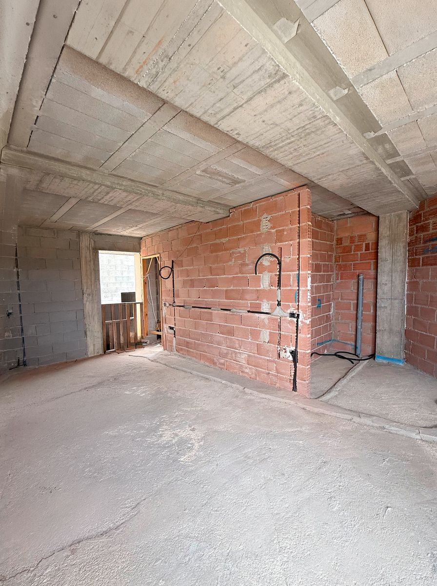 Salón en obra, con ladrillo visto y forjado de bovedilla